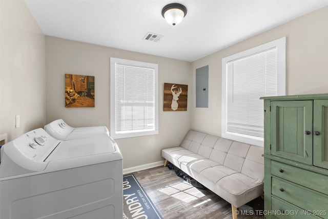 laundry room with visible vents, baseboards, light wood-style floors, independent washer and dryer, and electric panel