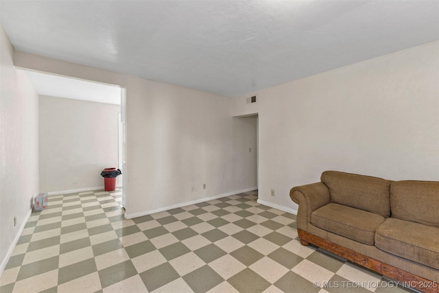 unfurnished living room with baseboards, visible vents, and light floors