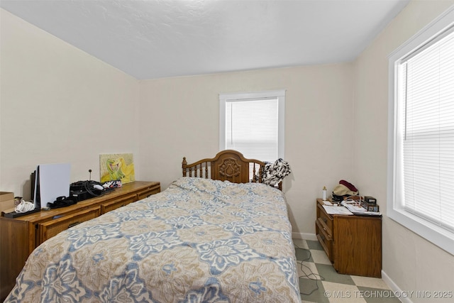 bedroom featuring multiple windows and baseboards