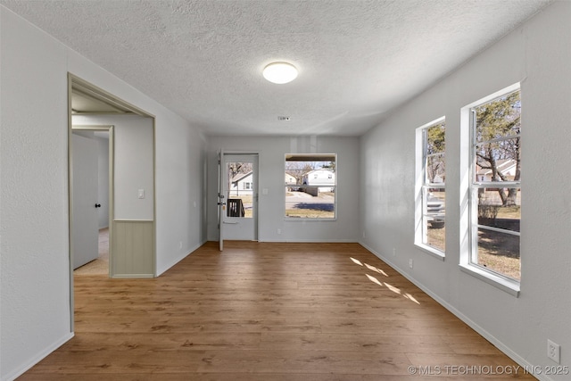 interior space with a textured ceiling and wood finished floors