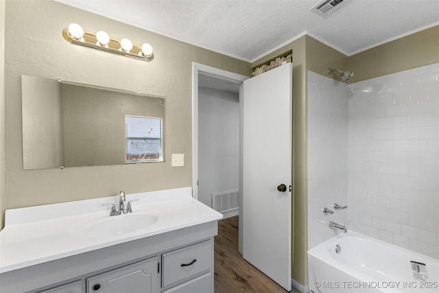 full bathroom featuring wood finished floors, visible vents, a textured ceiling, and bathing tub / shower combination