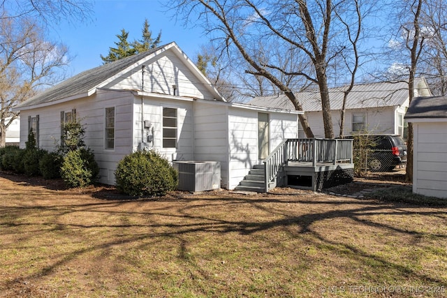 view of side of home with a yard and central AC unit