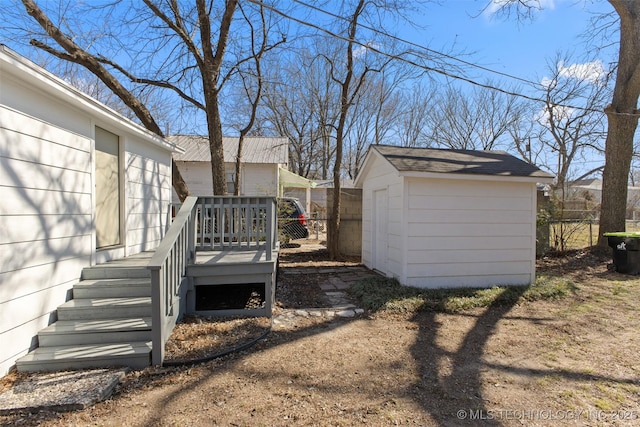 view of yard with an outbuilding, fence, a deck, and a storage shed