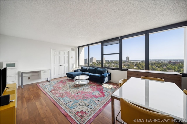 living area with a view of city, built in study area, a textured ceiling, and wood finished floors