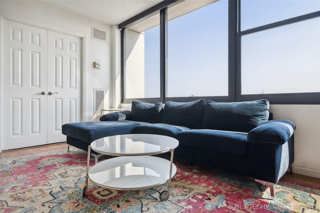 living area featuring a textured ceiling, wood finished floors, and visible vents