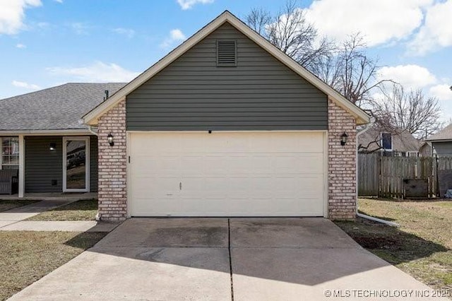 exterior space with driveway, an attached garage, fence, and brick siding