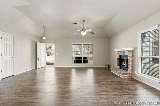 unfurnished living room featuring lofted ceiling, ceiling fan, dark wood-style flooring, visible vents, and a brick fireplace