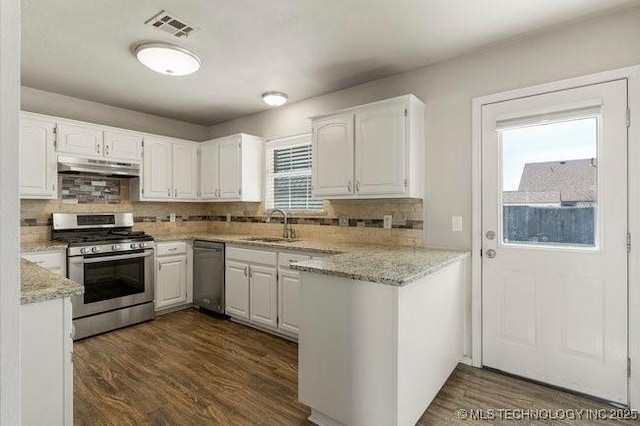 kitchen with stainless steel appliances, visible vents, white cabinets, a sink, and under cabinet range hood