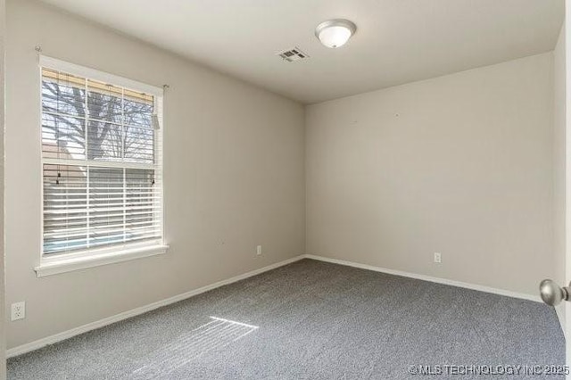 carpeted empty room featuring baseboards and visible vents