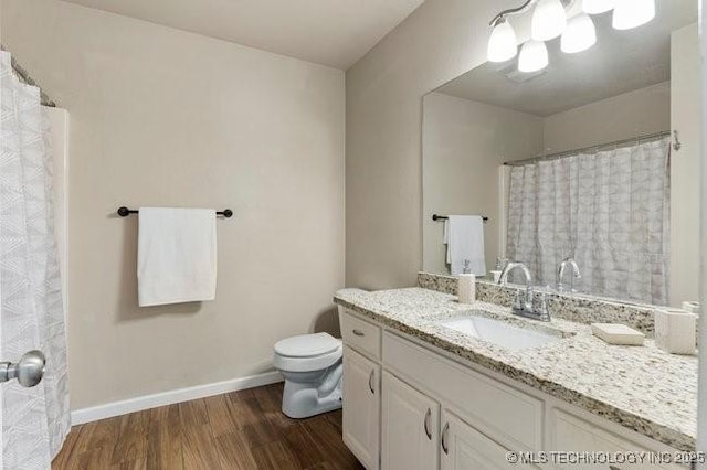 bathroom with baseboards, toilet, wood finished floors, curtained shower, and vanity