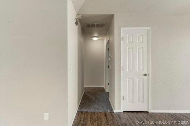 hall with visible vents, baseboards, and wood finished floors