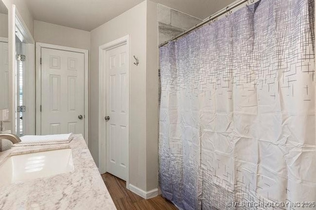 bathroom featuring a shower with curtain, a sink, and wood finished floors