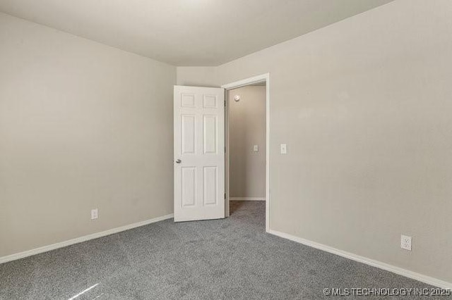 carpeted spare room with baseboards