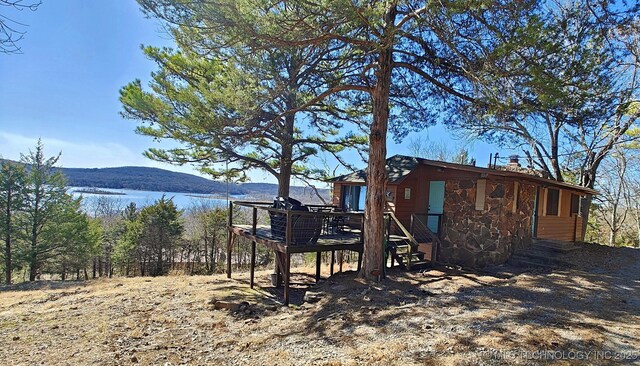 view of yard with a deck with water view