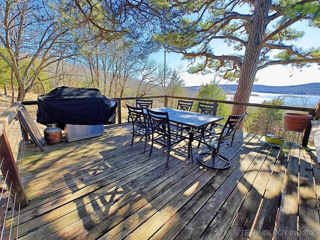 wooden terrace with outdoor dining space and a grill