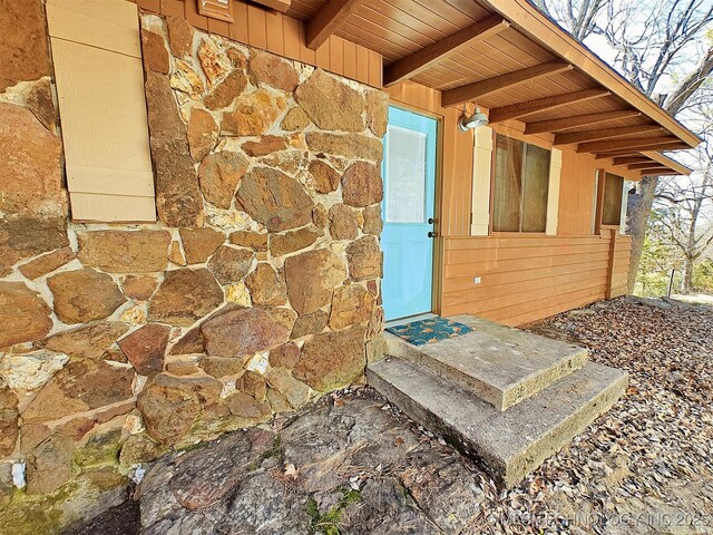 doorway to property with stone siding