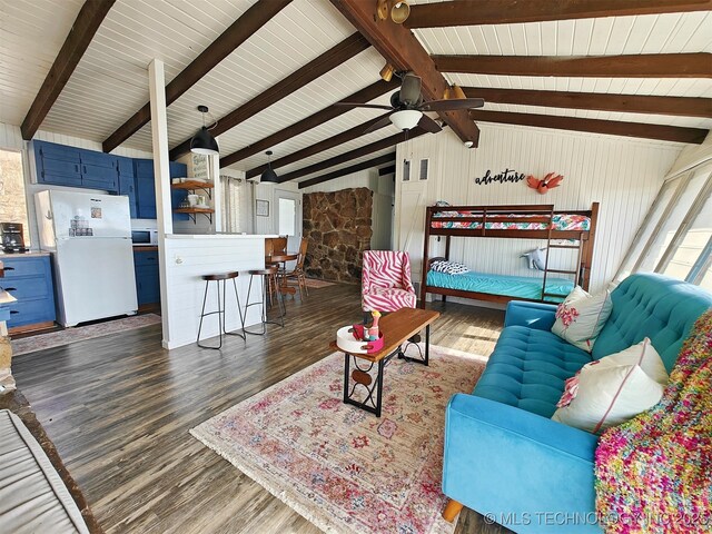 living room with vaulted ceiling with beams, wood finished floors, and a ceiling fan