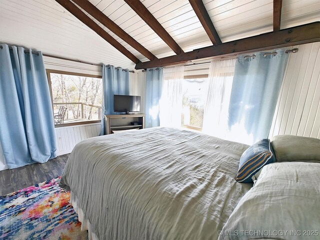 bedroom with wooden ceiling, vaulted ceiling with beams, wood walls, and wood finished floors