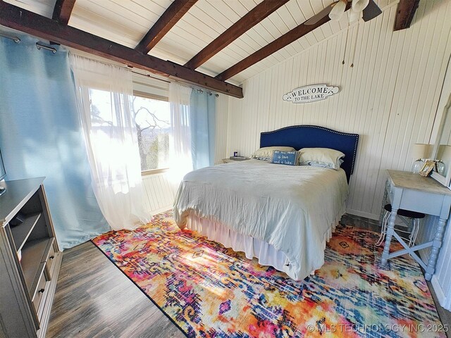 bedroom featuring vaulted ceiling with beams, wood walls, wooden ceiling, and wood finished floors