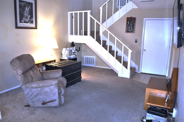 carpeted living room with baseboards, stairs, and visible vents