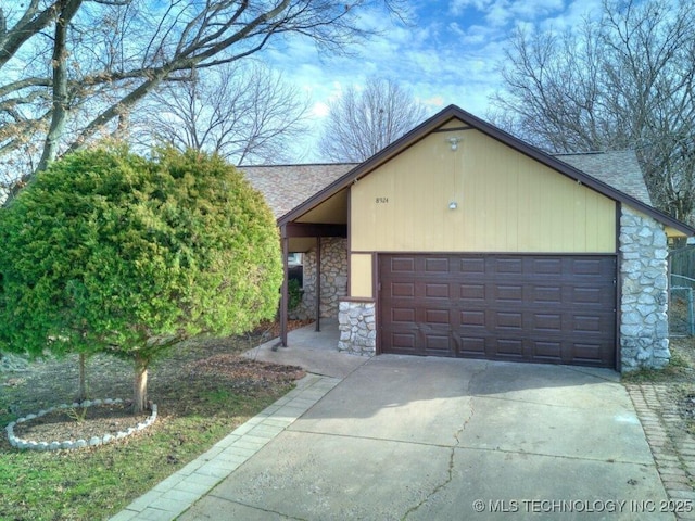 view of front of house with a garage, stone siding, roof with shingles, and concrete driveway