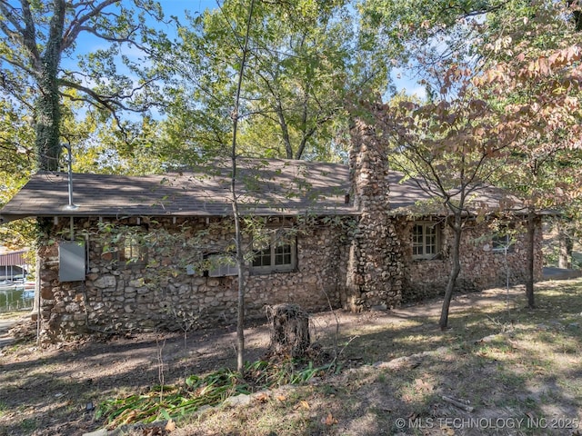 back of house featuring stone siding