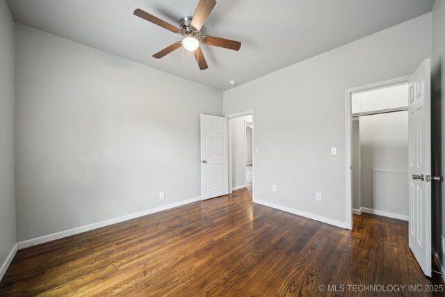 unfurnished bedroom featuring dark wood-style floors, a closet, and baseboards