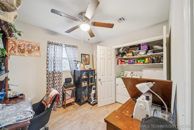 home office with light wood finished floors, visible vents, and a ceiling fan