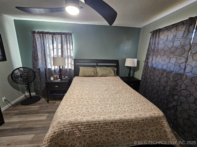 bedroom featuring baseboards, a textured ceiling, a ceiling fan, and wood finished floors