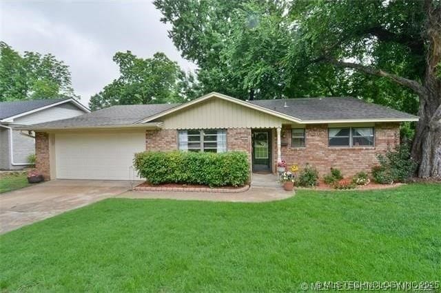 ranch-style home featuring a garage, concrete driveway, brick siding, and a front yard