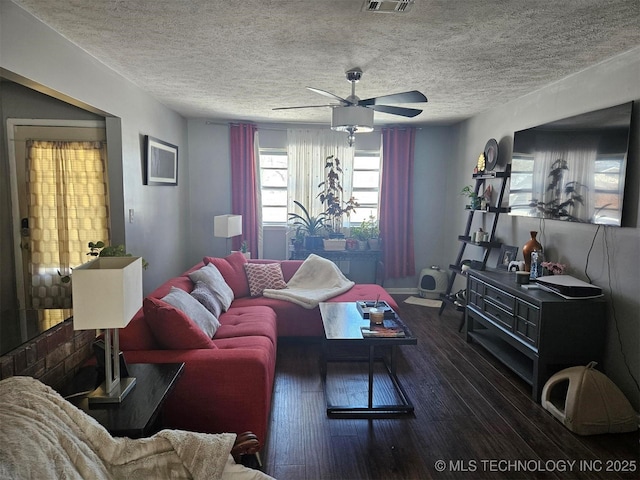 living area with a textured ceiling, visible vents, wood-type flooring, and a ceiling fan