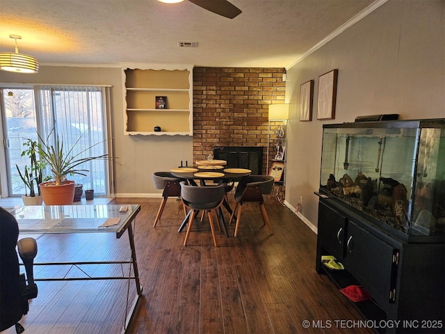 dining area featuring a textured ceiling, wood-type flooring, baseboards, and crown molding