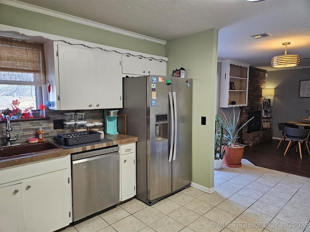 kitchen with white cabinets, tasteful backsplash, stainless steel appliances, and a sink