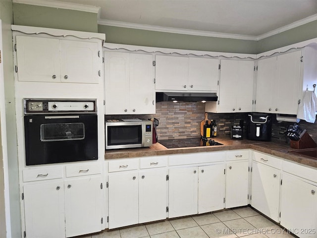 kitchen featuring wall oven, stainless steel microwave, black electric cooktop, crown molding, and under cabinet range hood
