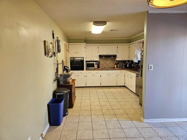 kitchen featuring tasteful backsplash, white cabinets, light tile patterned flooring, a textured ceiling, and black appliances