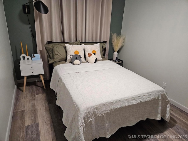 bedroom featuring baseboards and wood finished floors