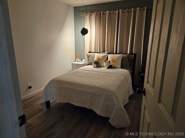 bedroom featuring dark wood finished floors and baseboards