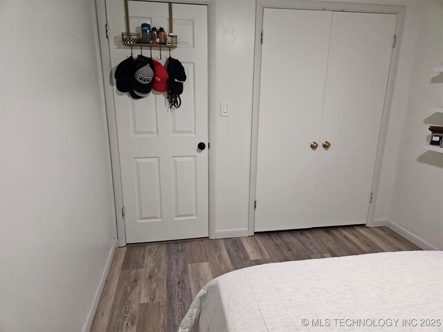 bedroom featuring wood finished floors and baseboards