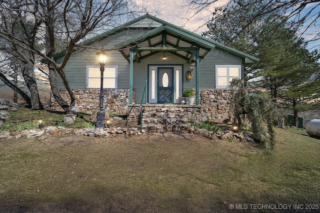 exterior entry at dusk with stone siding