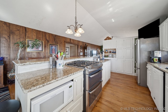 3126 E 490th Rd, Pryor, OK 74361 - kitchen featuring wooden walls, white cabinets, white appliances, a chandelier, and light wood-type flooring
