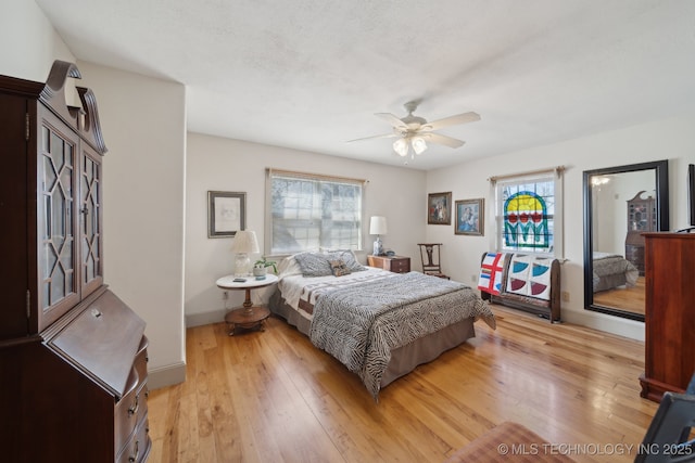 3126 E 490th Rd, Pryor, OK 74361 - bedroom featuring baseboards, light wood finished floors, ceiling fan, and multiple windows