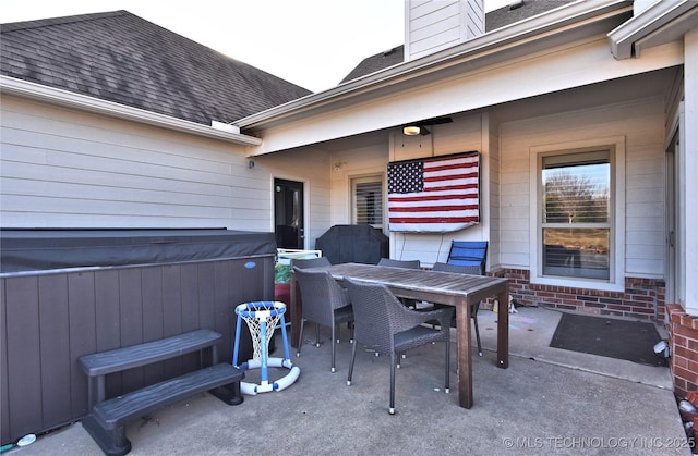 view of patio with a hot tub and outdoor dining space