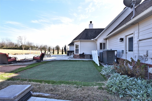 view of yard with central AC unit and a patio