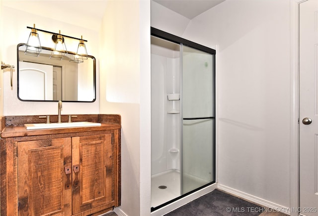 full bathroom with a shower stall, baseboards, and vanity