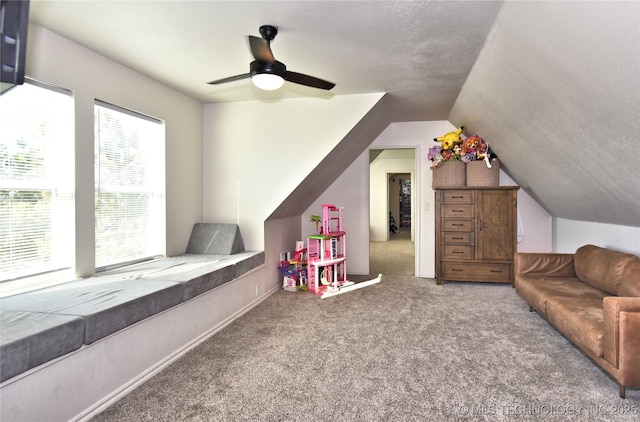 rec room featuring lofted ceiling, ceiling fan, a textured ceiling, and carpet flooring