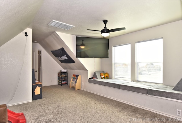 playroom featuring carpet, visible vents, ceiling fan, and a textured ceiling