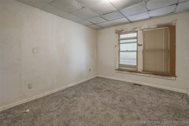 spare room with a drop ceiling, carpet, visible vents, and baseboards