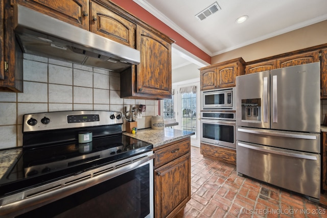 kitchen with visible vents, decorative backsplash, ornamental molding, stainless steel appliances, and under cabinet range hood