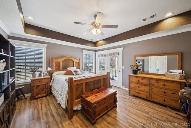 bedroom featuring baseboards, visible vents, ceiling fan, wood finished floors, and access to outside