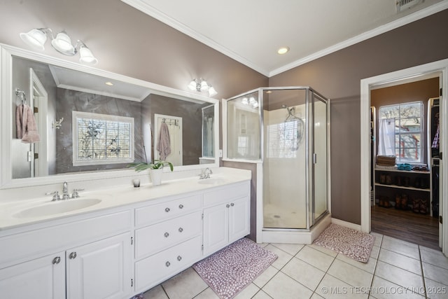 bathroom featuring a shower stall, ornamental molding, a sink, and tile patterned floors